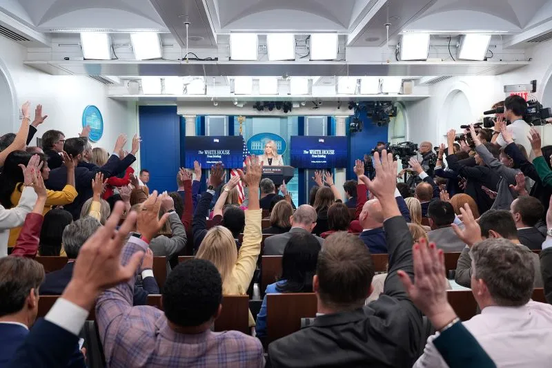 Reporters raise their hands to ask questions during a briefing by White House press secretary Karoline Leavitt on Friday.