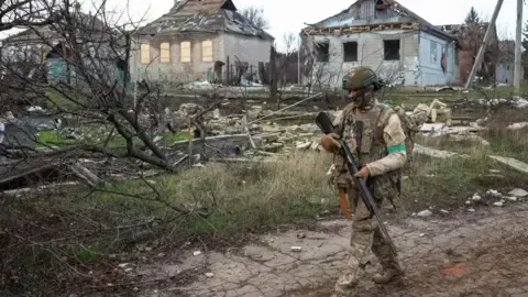 Reuters A Ukrainian soldier carrying a gun on patrol in Donetsk 