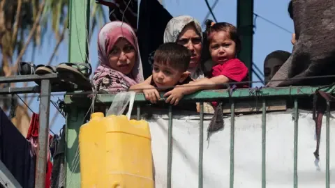 Reuters Palestinians look on at the site of an overnight Israeli strike on a school sheltering displaced families, in Gaza City