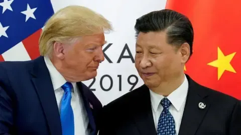 Reuters Trump looking at Xi, their faces quite close, with the flags of their countries behind them.
