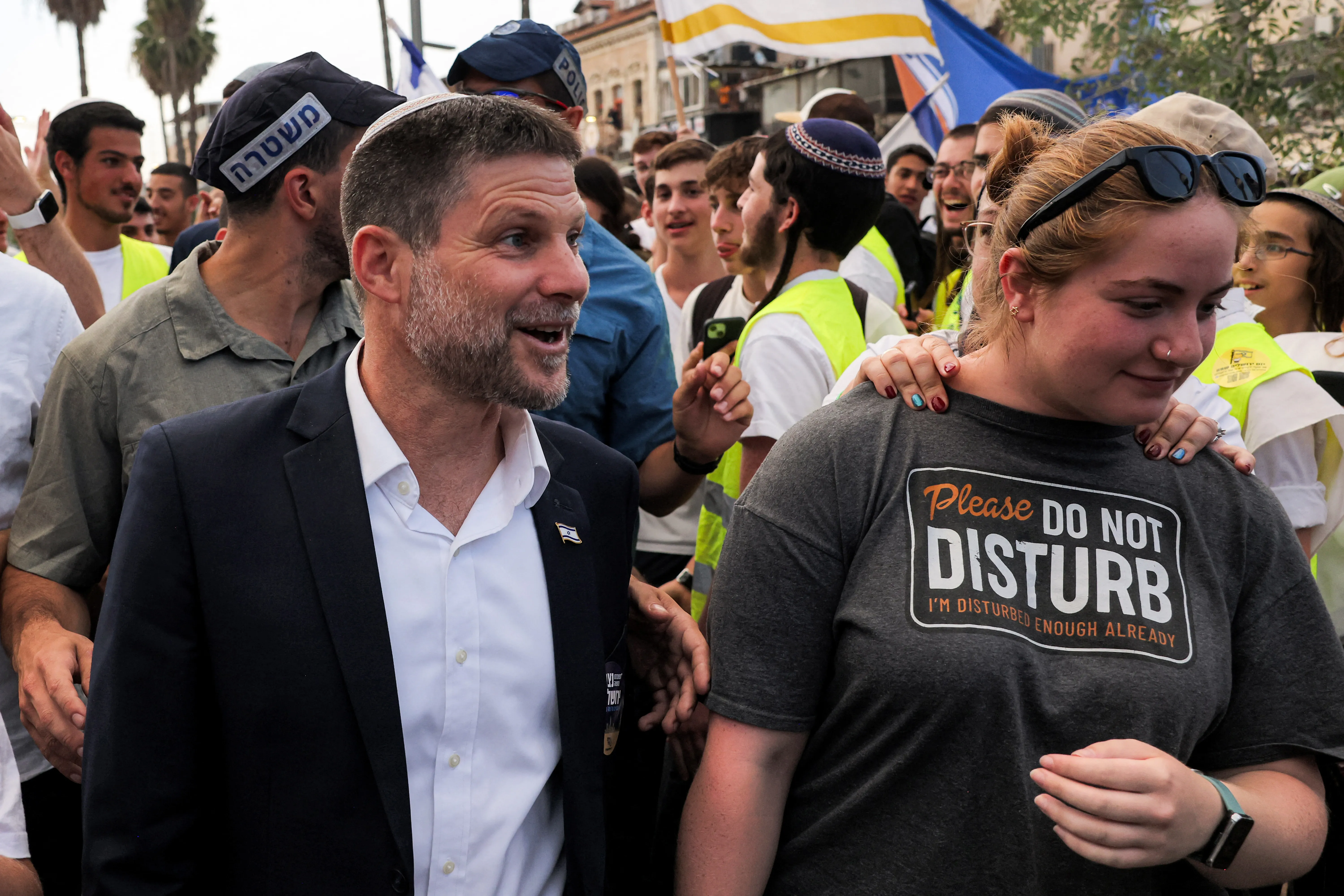 a man in a suit smiles in a crowd
