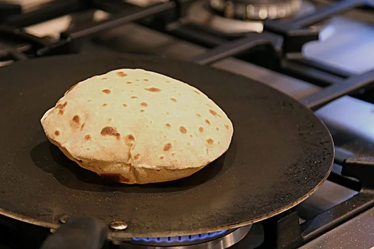 This may contain: a tortilla sitting on top of a frying pan next to an oven