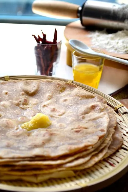 This may contain: a stack of tortillas sitting on top of a table next to a cup