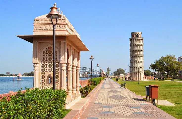 This may contain: a walkway next to the water with a tower in the background