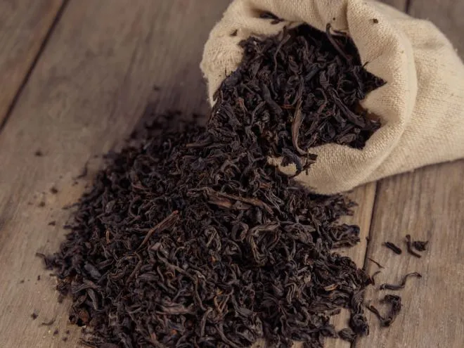 This may contain: a pile of tea sitting on top of a wooden table next to a cloth bag