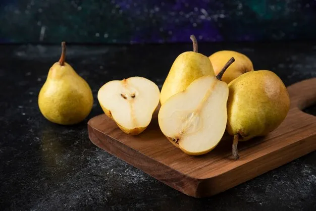 Free photo wooden board of delicious yellow pears on black surface.