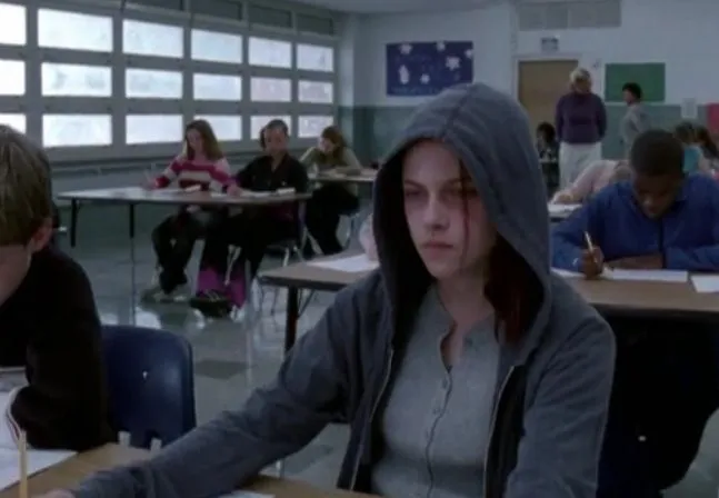 This may contain: a group of people sitting at desks in a classroom with one person writing on a piece of paper