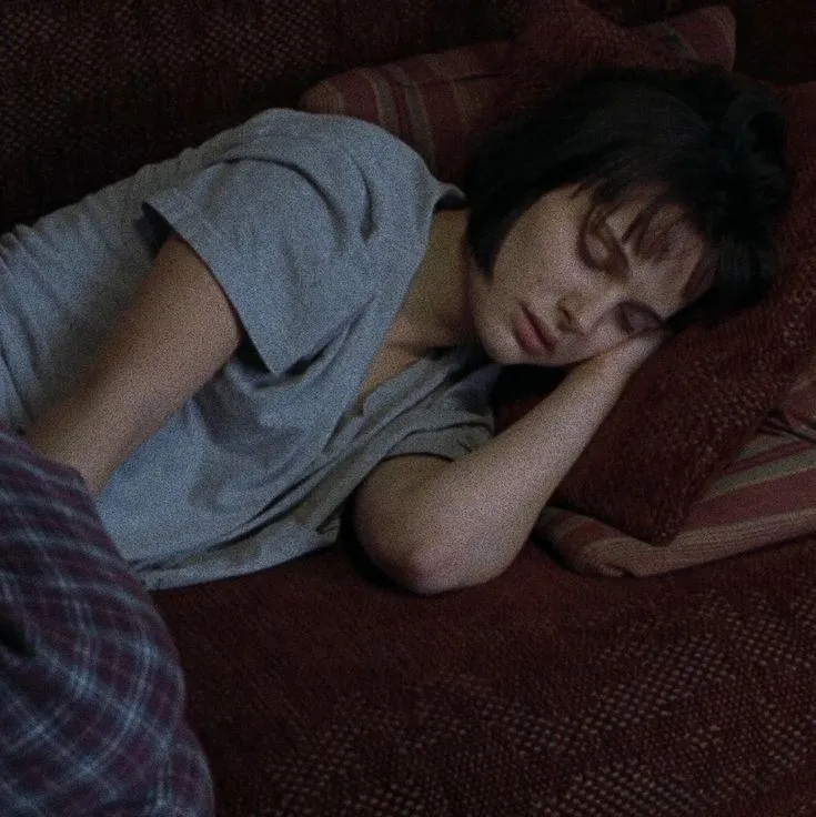 This may contain: a woman laying on top of a couch next to a man