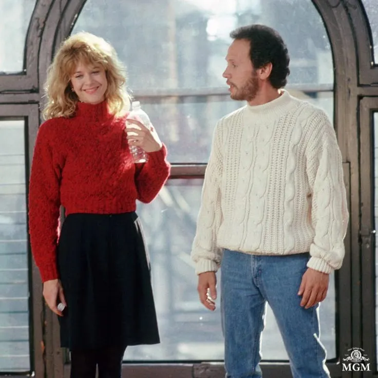 This may contain: a man and woman standing next to each other in front of a large window with arched windows