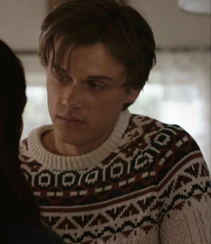 This may contain: a man in a sweater looking at another person's face while they both stare into each other's eyes