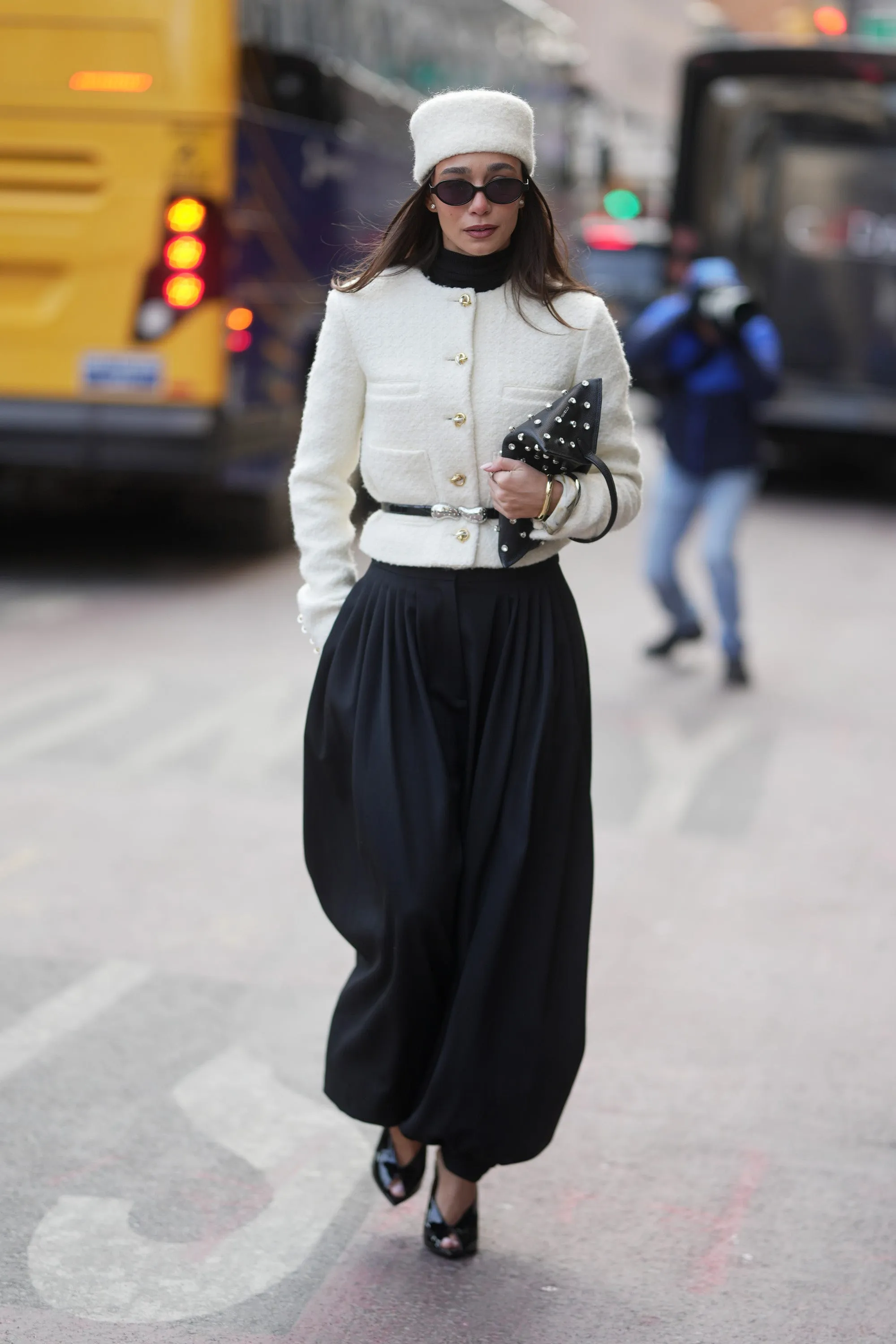 new york, new york february 14 blanca arimany is seen wearing a white pillbox hat, black sunglasses, gold stud earrings, a white boucl&eacute; buttonup jacket, a black turtleneck, a black leather belt with silver hardware, black voluminous harem trousers, and black patent leather opentoe heels, while carrying a black leather clutch with silver stud detailing during new york fashion week fall winter 2026 on february 14, 2026 in new york city photo by 305picsgetty images