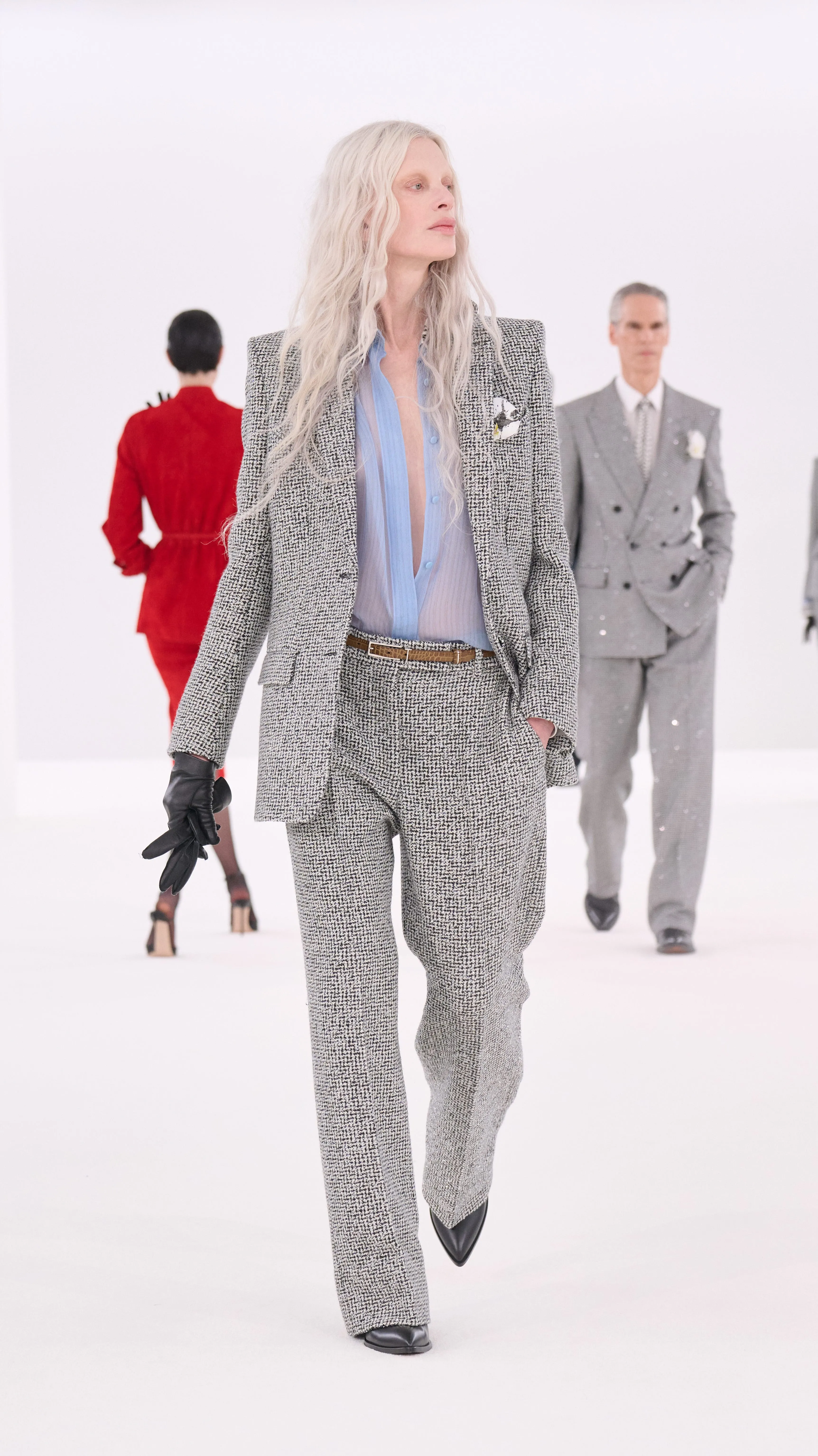 Models showcasing high fashion attire on a runway.