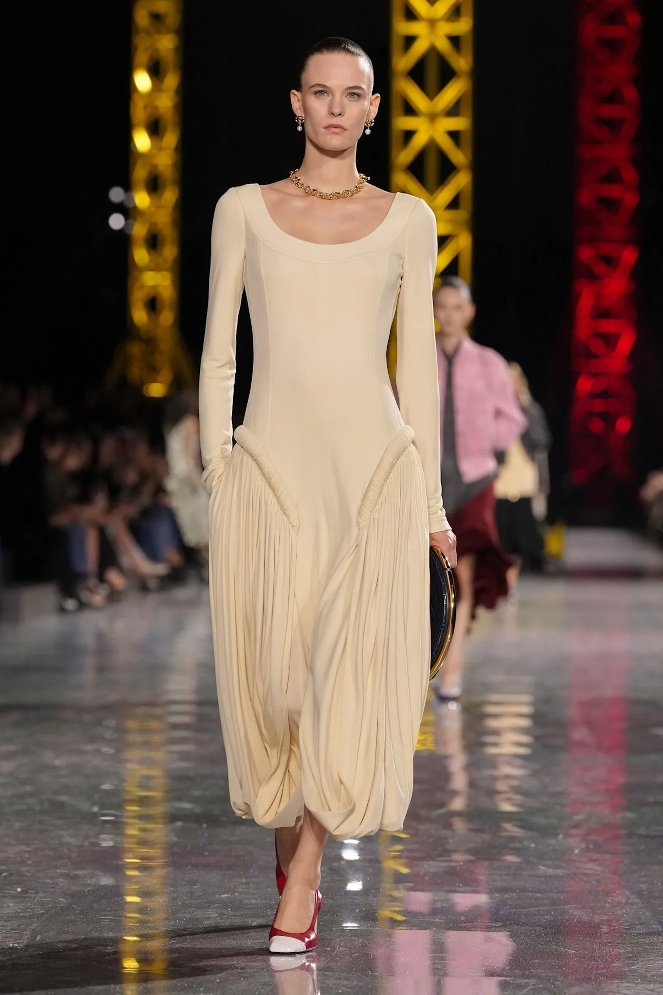 Model showcasing a fashion design on a runway.