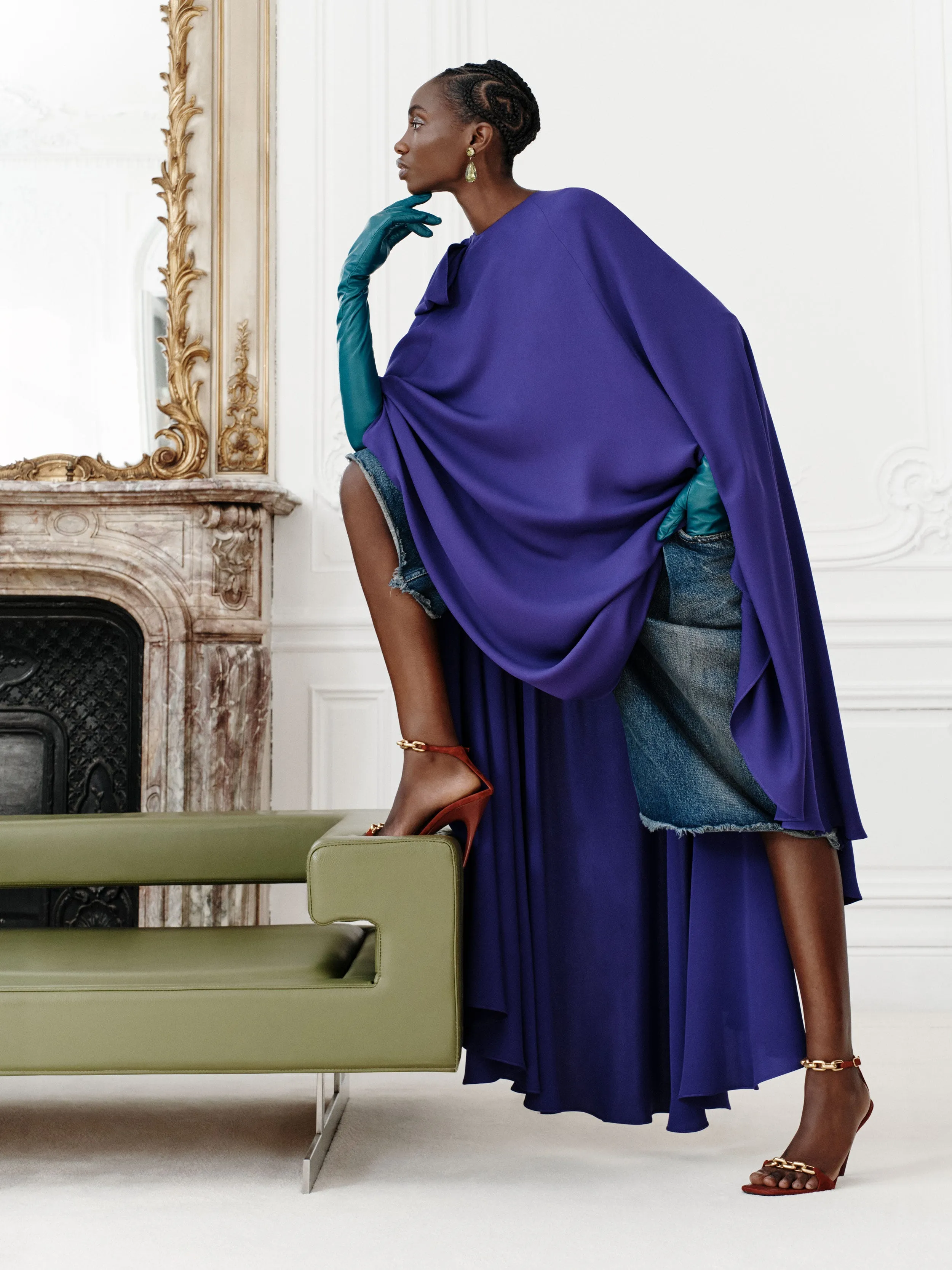 Fashion model in a striking purple garment with denim elements.