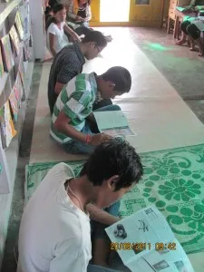 Children reading inside the Apne Library, Wakro