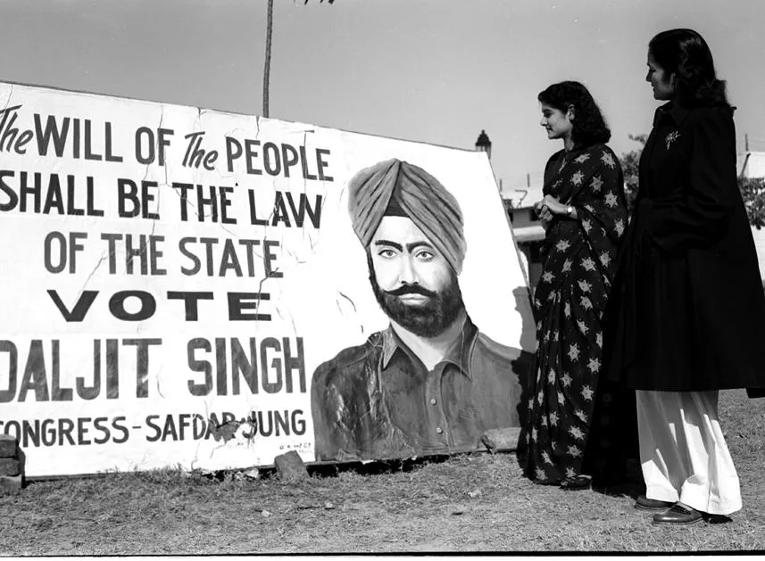 Young lady voters reading the poster of a Congress candidate.