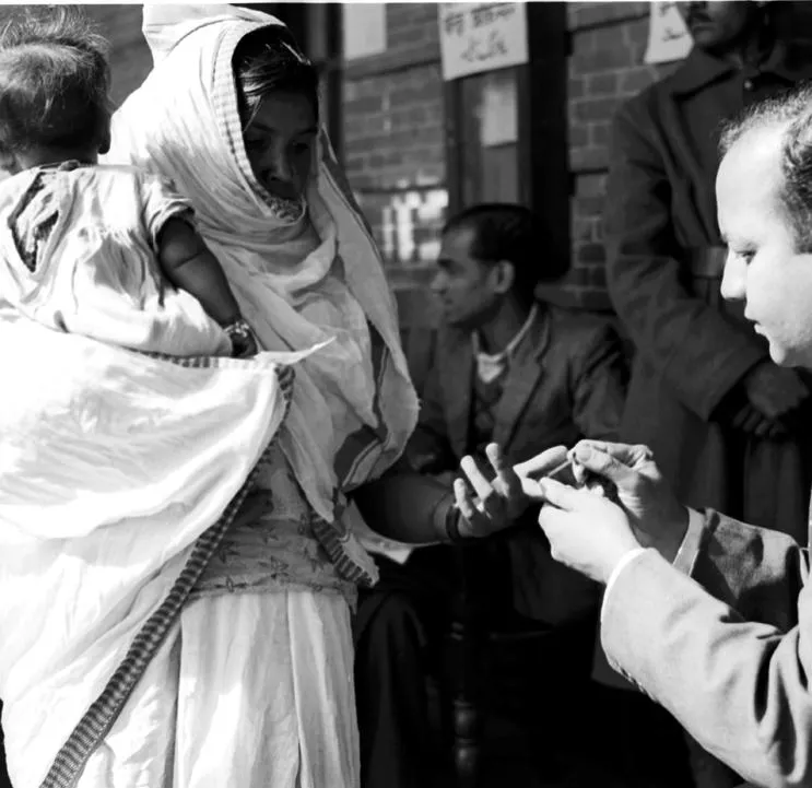 A Polling Officers affixes indelible ink mark on the fore-finger of a voter before allowing her to cast the vote.