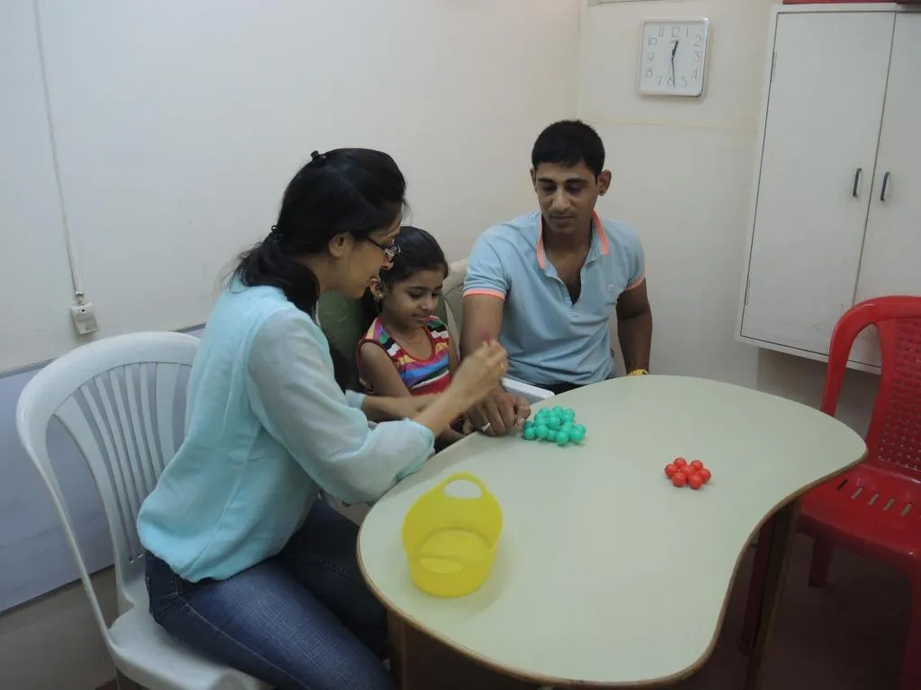 A teacher with the student and his father engages them in therapy sessions.