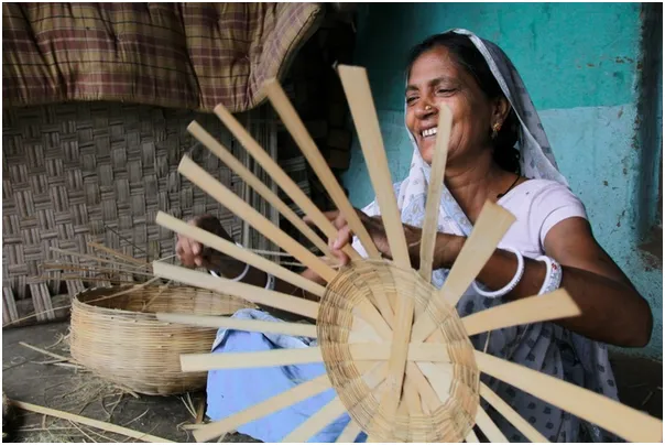 Mangudi, a Bhil artisan, sells baskets and brooms in the local market.