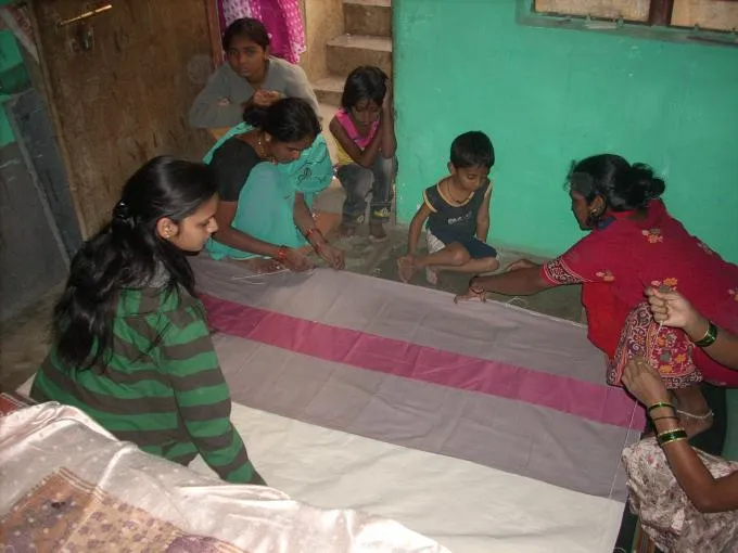 The women from slums make bags out of old saris to get some extra income.