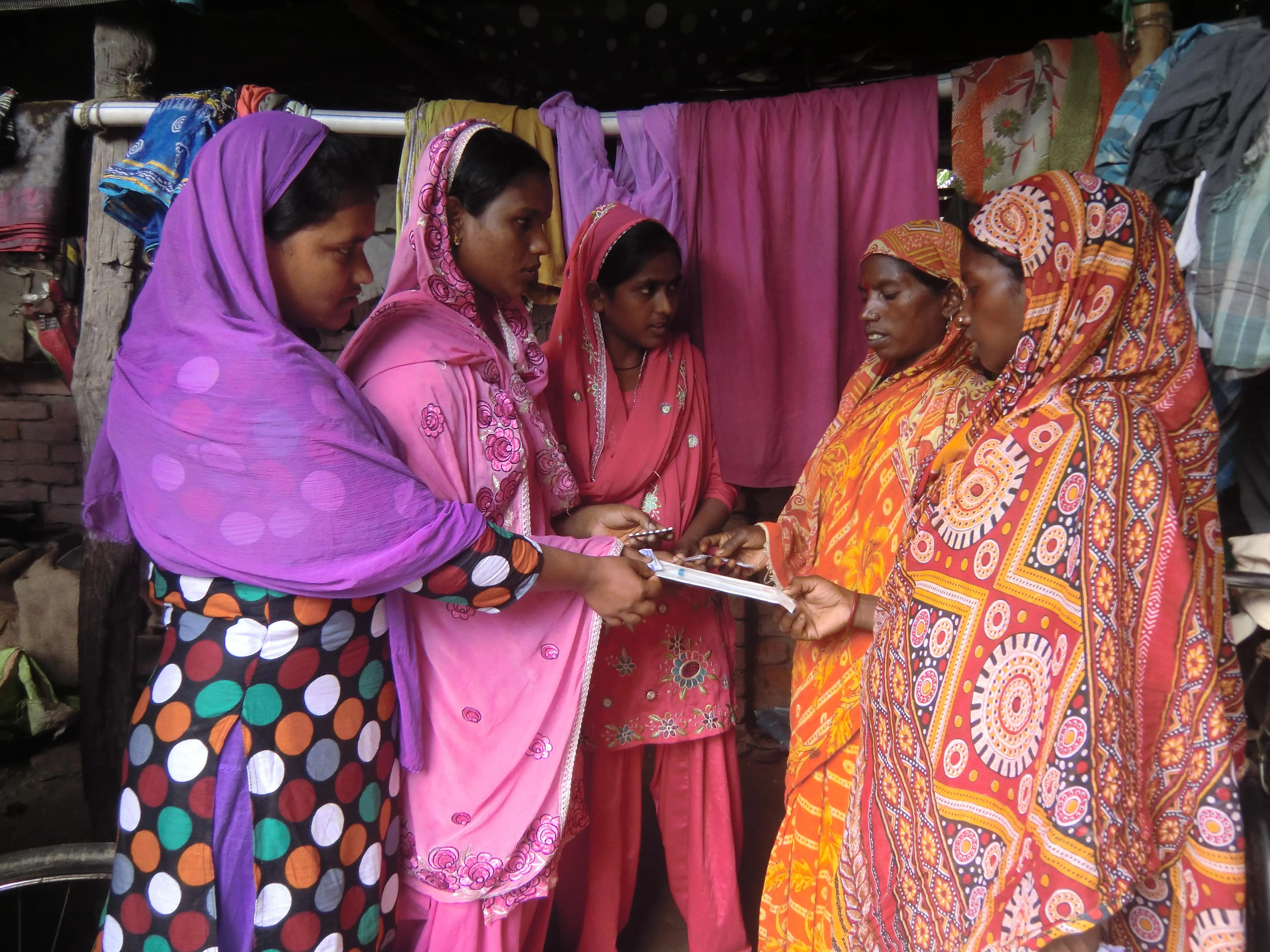 Without inhibition, the Kishori group members of Nooniya Basti interact with older women showing them samples of contraceptive pills, Copper T and condoms and telling them about the merits of keeping at a five-year gap between children. (Credit: Ajitha Menon\WFS)