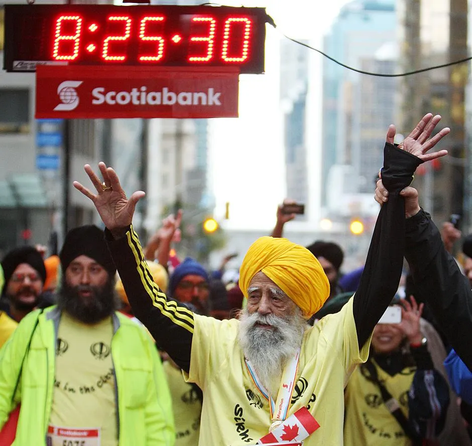 Fauja Singh waves to supporters minutes after finishing the 2011 Toronto Scotiabank Marathon