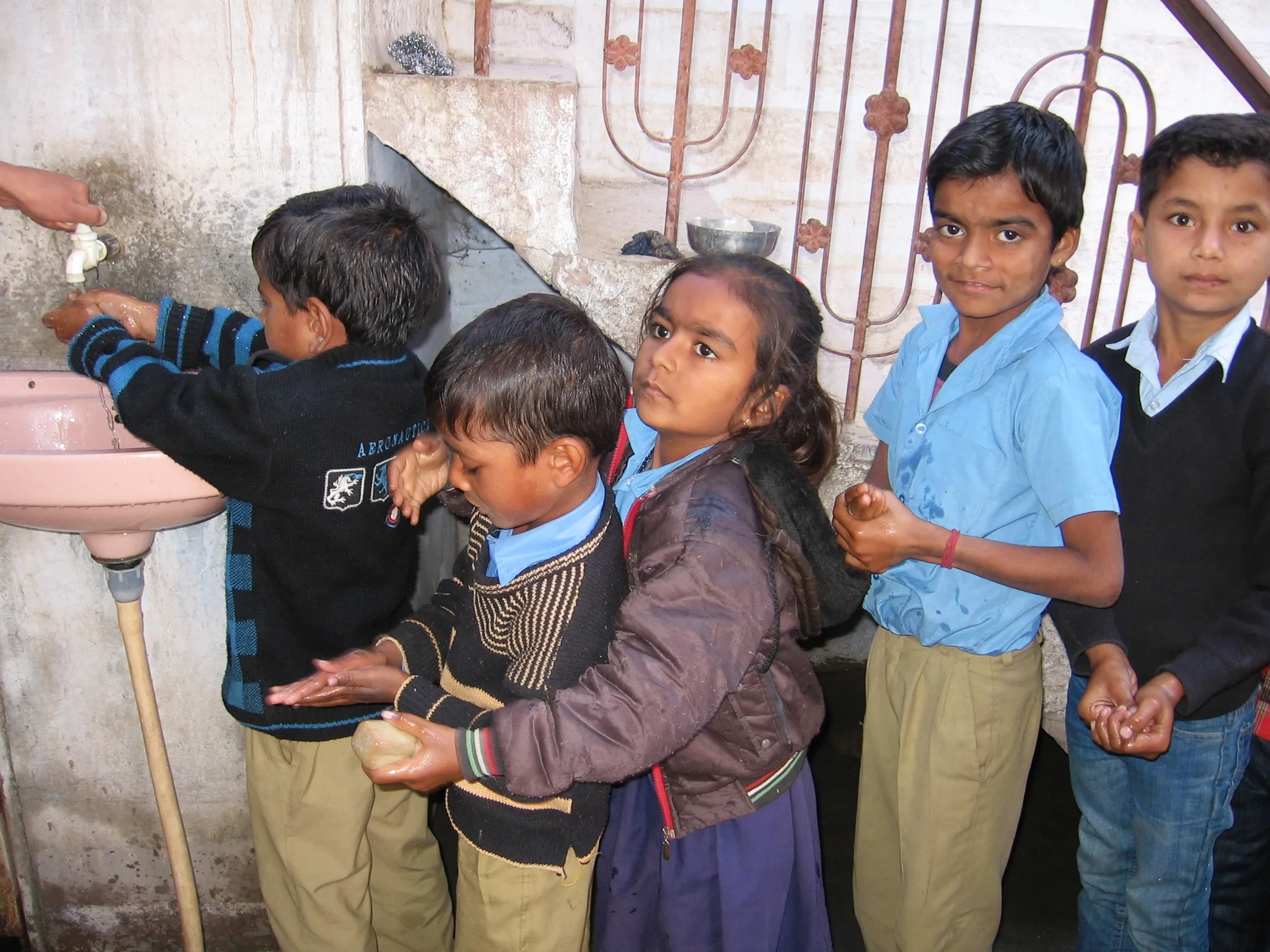Children queue up to wash their hands before sitting down to have the hot and wholesome mid day meal served at their school. (Credit: Abha Sharma/WFS) 