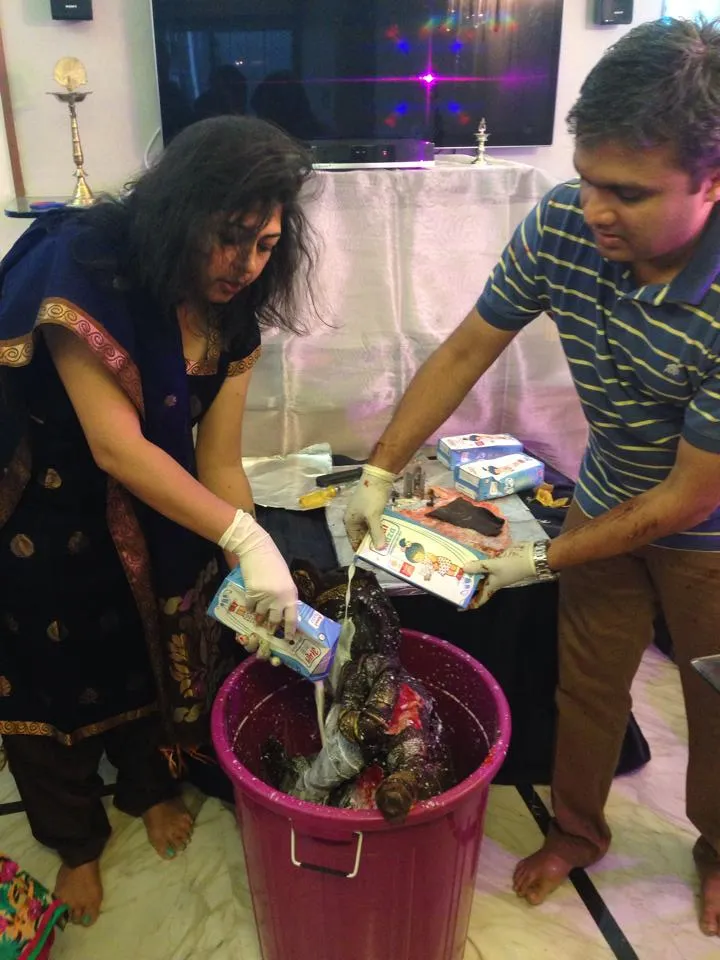Rintu and her husband immersing the idol into milk