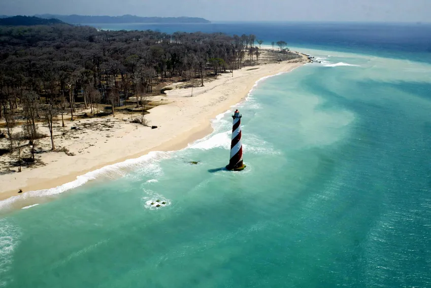 An aerial view of the damaged coast of Indira Point, India's southern most point, 600 km (about 375 miles) south of Port Blair, in the Andaman and Nicobar archipelago March 1, 2005. The tsunami which swamped Asian coastlines just over two months ago not only killed thousands of people in India's Andaman and Nicobar islands, it also hurt a vital part of the country's defences. Picture taken on March 1, 2005. REUTERS/Sucheta Das Die Landzunge Indira Point auf Car Nicobar, die den südlichsten Ort des indischen Staatsgebietes bildet, versank während des Tsunami 2004 im Meer. Der Leuchtturm am Indira Point steht wie ein Mahnmal im Wasser.