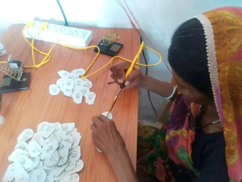 Tribal women like Rukmini are now familiar with all the parts of the portable solar lamp that they assemble efficiently. (Credit: Renu Rakesh\WFS)