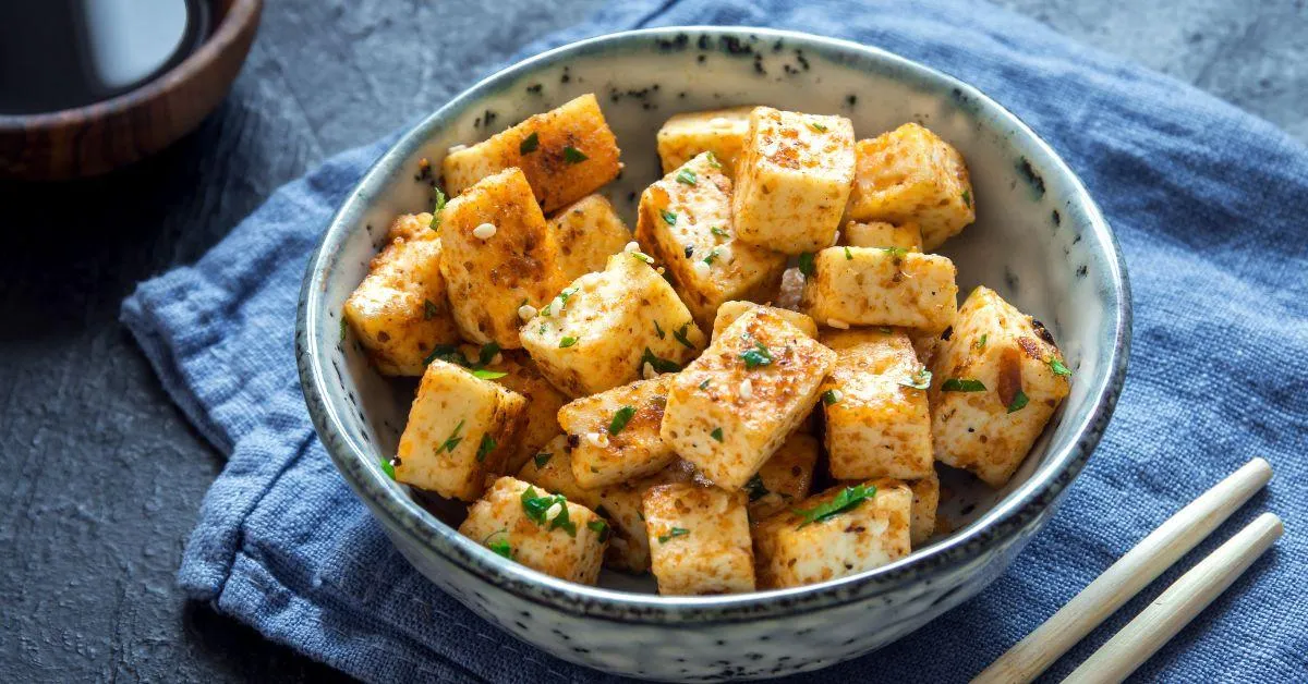 Stir Fried Tofu in a bowl with sesame and greens. Homemade healthy vegan asian meal - fried tofu.