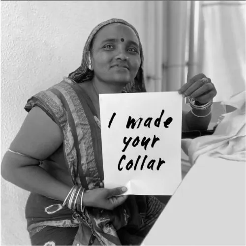 A woman proudly holds a card that reads, 
