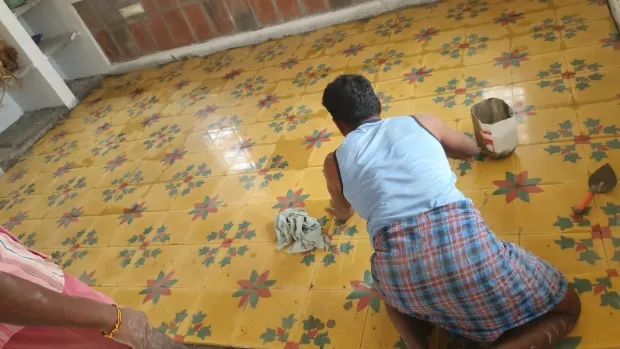 A worker installing the Athangudi Tiles