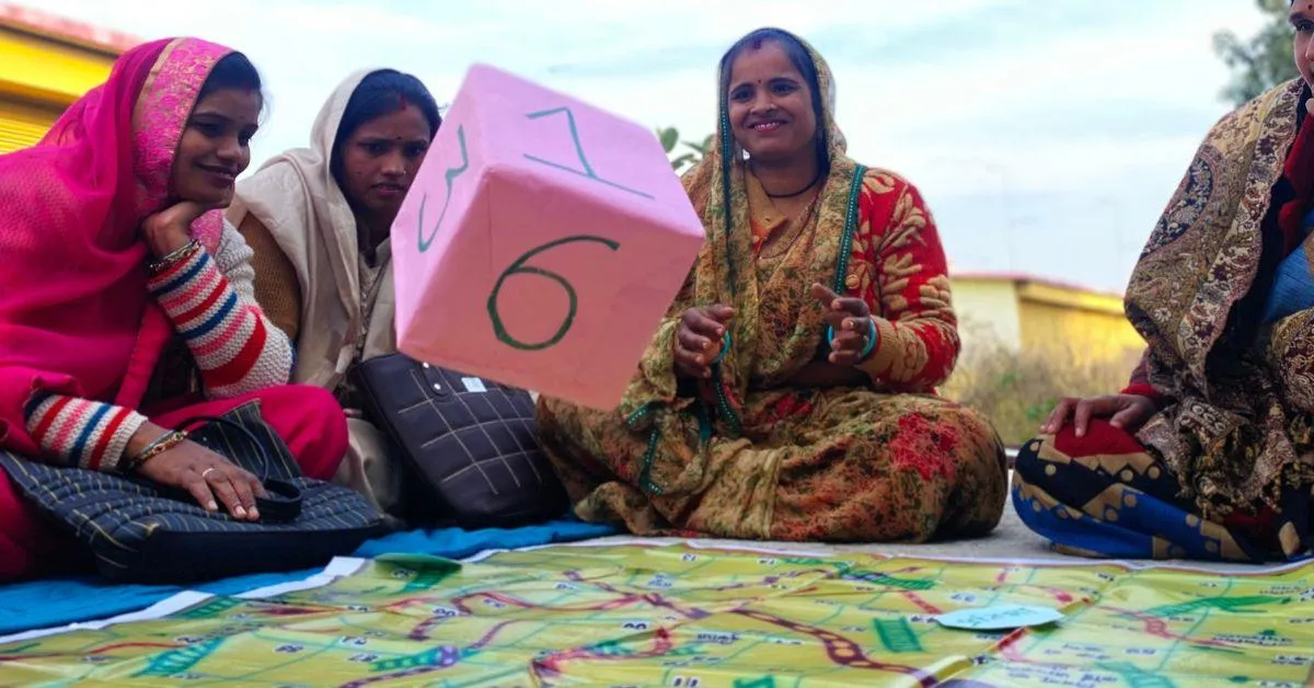 Community listening session with a CLF in Ghuguwa, Jhansi, Uttar Pradesh using a specifically designed snake and ladder game.