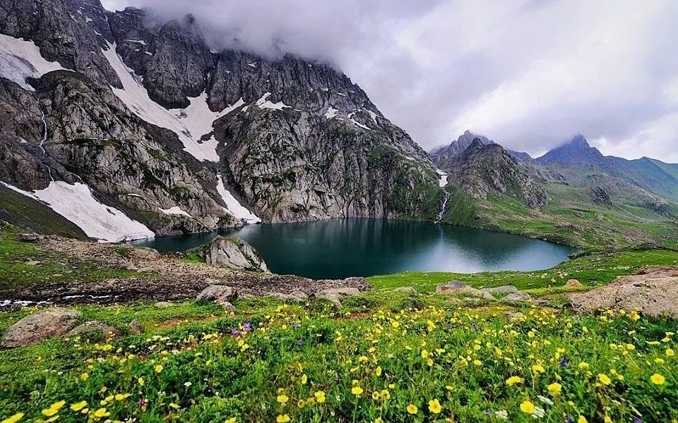 Gadsar Lake glows like a sapphire framed in snow — mysterious, magnificent, and wrapped in wildflowers.