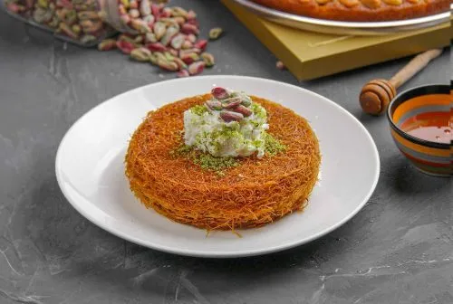 Beautifully crafted Kunafah made from golden, crispy kataifi (shredded phyllo dough), layered and baked.