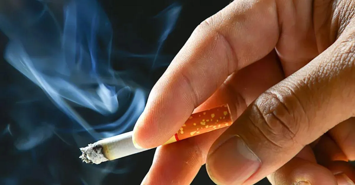 a person holding a cigarette in hand