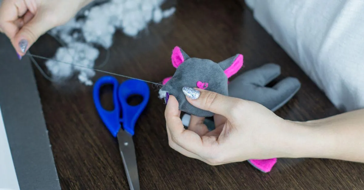 a person sewing an old toy.