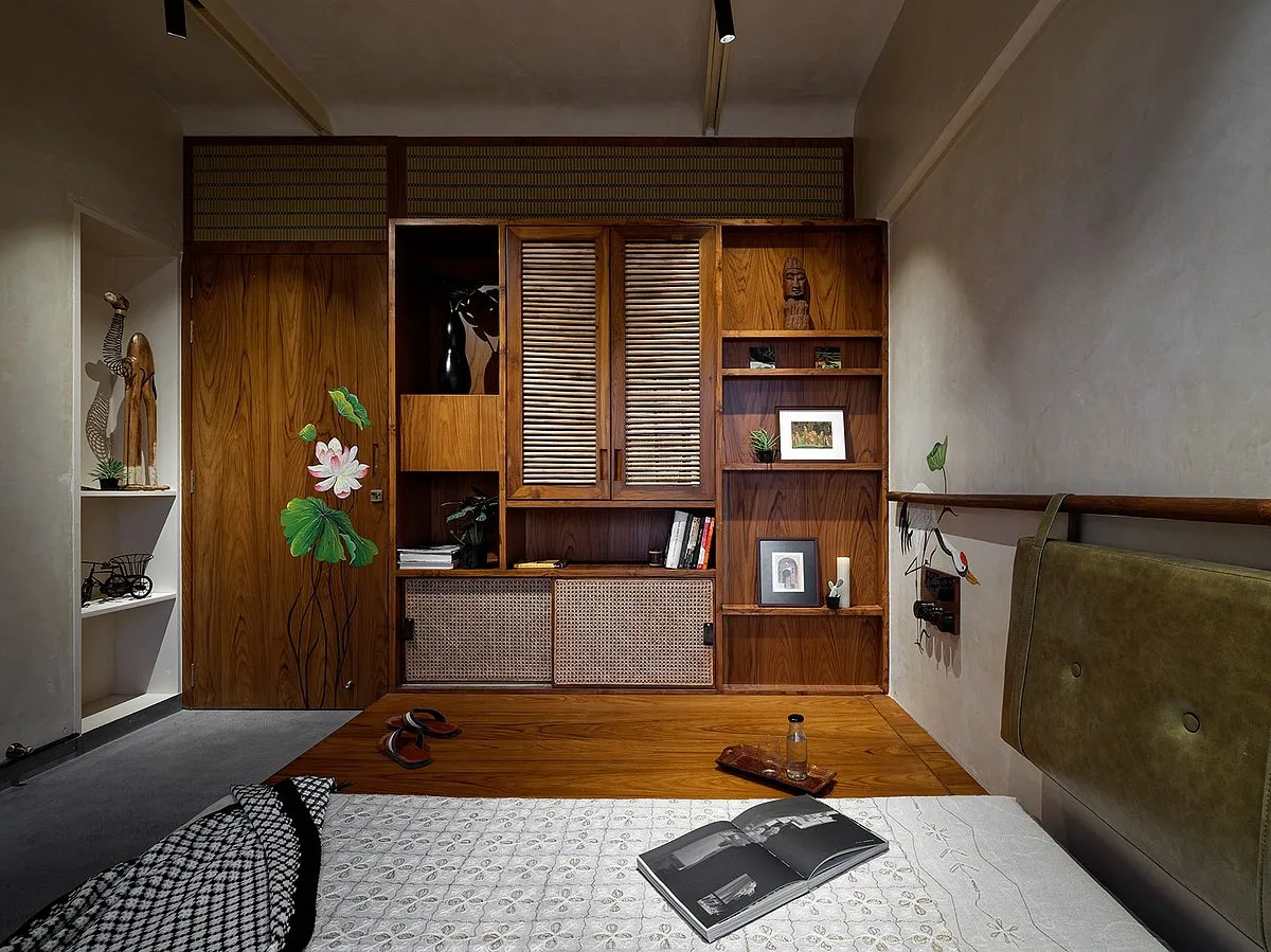 Folk House by Mind Manifestation Design LLPSince maximising the compact carpet of 800sq ft and providing ample storage was a client requirement, one bedroom in the apartment has been converted into a multi-purpose space, achieved by demolishing a partition wall and converting it into storage units. A permanent platform was also designed — the couple can use it for exercises and games, and when guests come over, it can be utilised for sleeping. Additionally, a sliding partition crafted from solid wood in vertical battens separates the private areas from the semi-private ones. The project was crafted and manufactured locally, emphasising local Indian arts. 