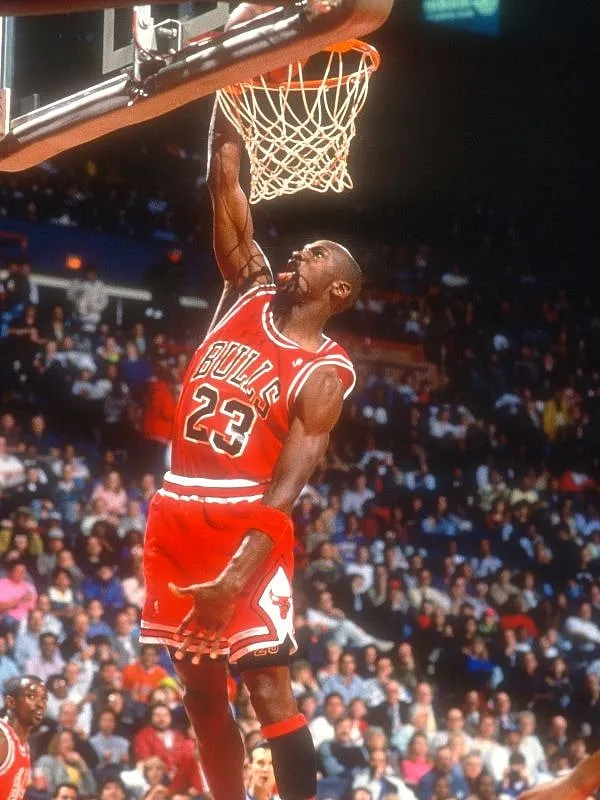 Michael Jordan flying mid-air like a virile beast. Image: Getty 