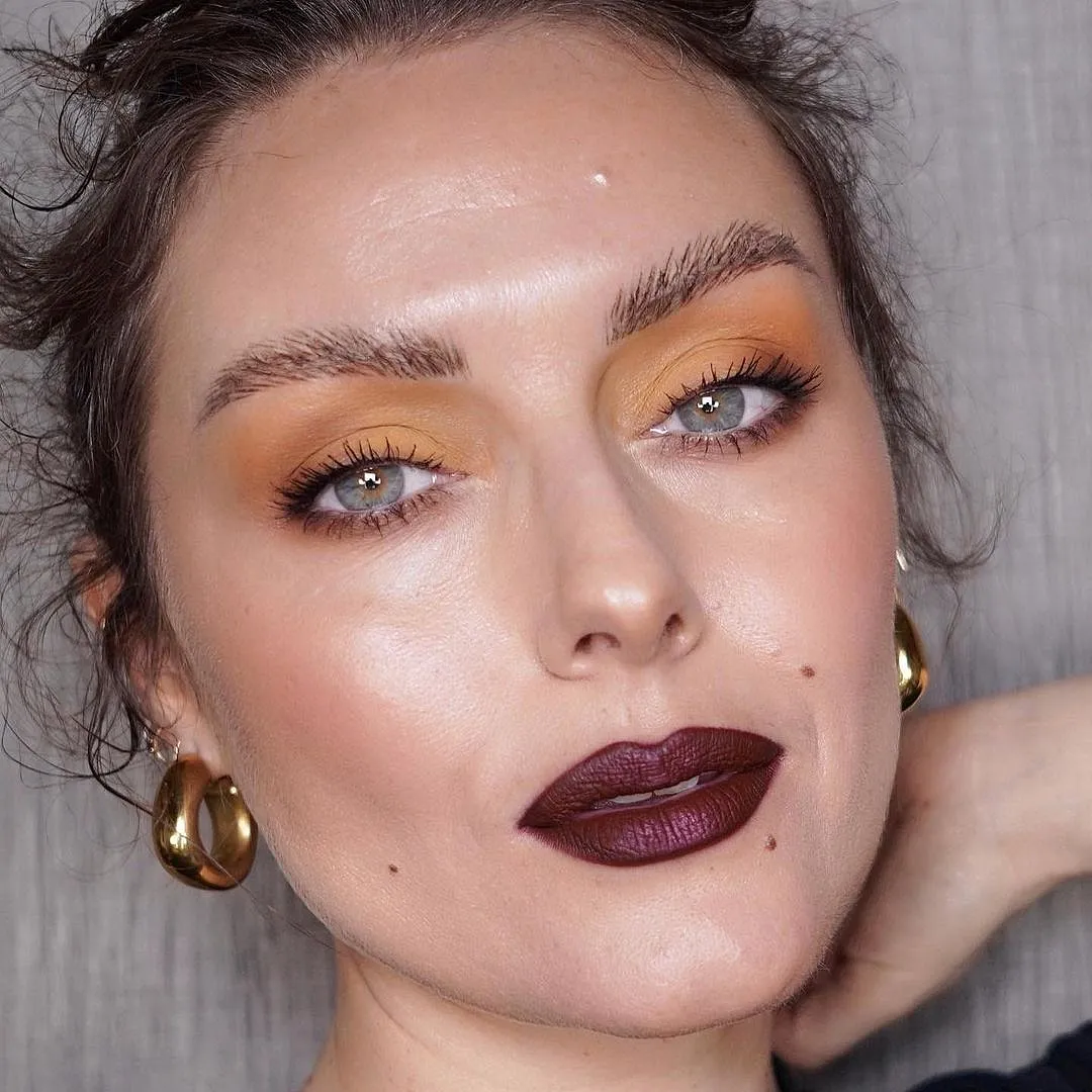 Katie Jane Hughes Scrolling through Instagram can feel like a flood of taupe cut-creases and contouring tutorials, but Katie Jane Hughes treats things a little differently. She doesn’t choose the beige and neutral route, instead experimenting with bright colours—yellow eyeshadow and purple lips, for example—highlighted by her juicy, dewy skin. 