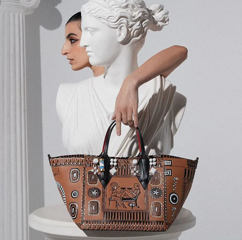 The black and white embossment over brown leather is inspired by Greek pottery  