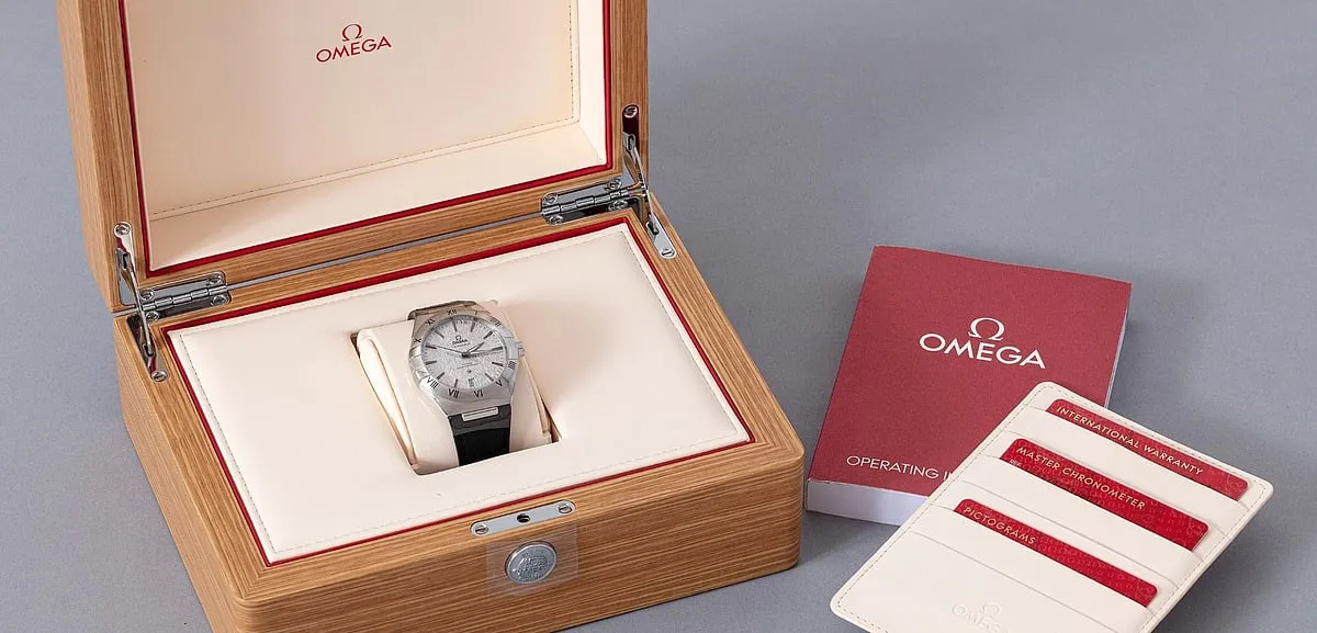 The Omega Constellation comes with a silk-embossed rhodium-grey dial, date window at the 6 o'clock position, with blackened facetted hour indexes, black rubber strap, and a scratch-resistant sapphire crystal 