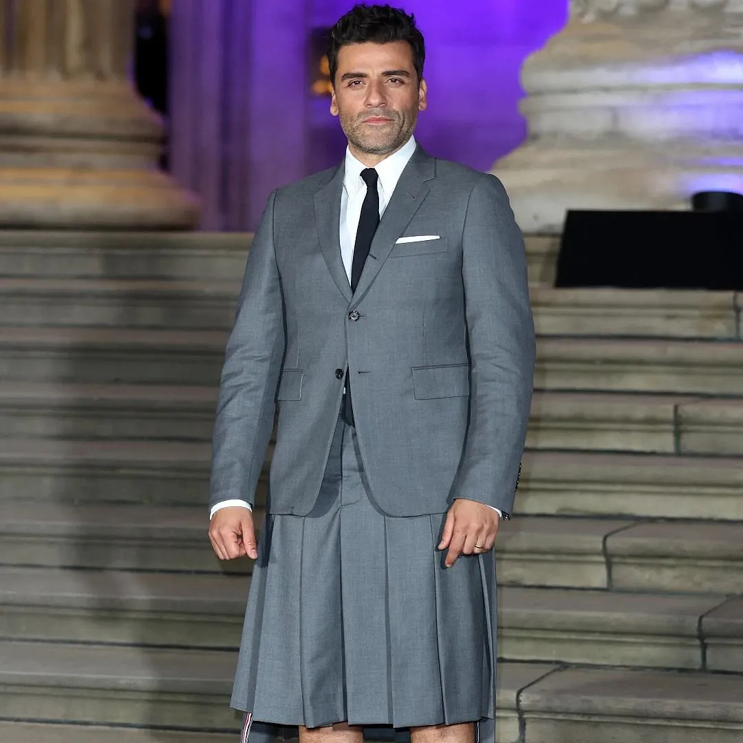 Actor Oscar Isaac in a grey pleated skirt on the red carpet of the Venice Film Festival 