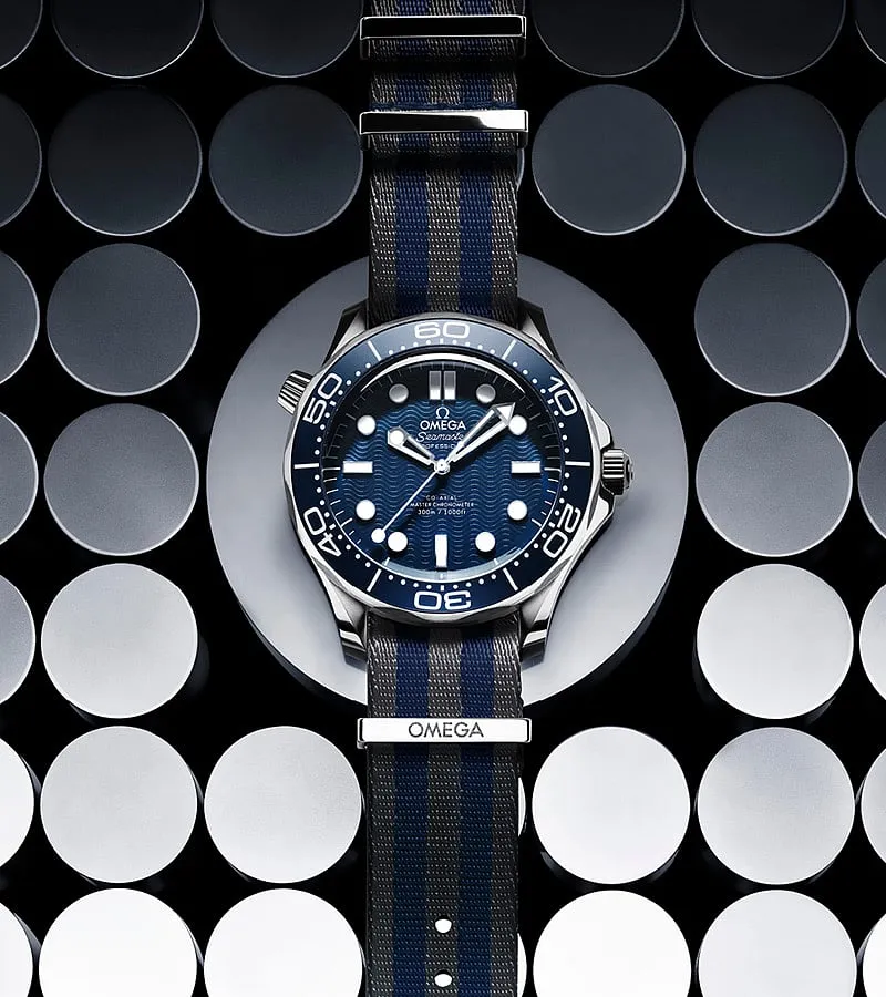 Omega Seamaster:While the ‘Seamaster’ was once primarily a dive watch, it has become accessible to a hardcore diver and the CEO of a multinational company. The origin of ‘Seamaster’ dates back to 1948 when the watchmakers introduced it as a part of their 100th birthday celebration. Fast-forward to 1995, and actor Pierce Brosnan wore it in Goldeneye. The latest version of the ‘Seamaster’ is sleeker, with two new releases; both ‘Seamaster Diver 300m,’ the 42-mm model commemorates the 60th anniversary of the 007 movie franchise. The blue-on-blue one has a dial with laser-engraved waves and a striped NATO strap (worn by James Bond in Goldfinger). 