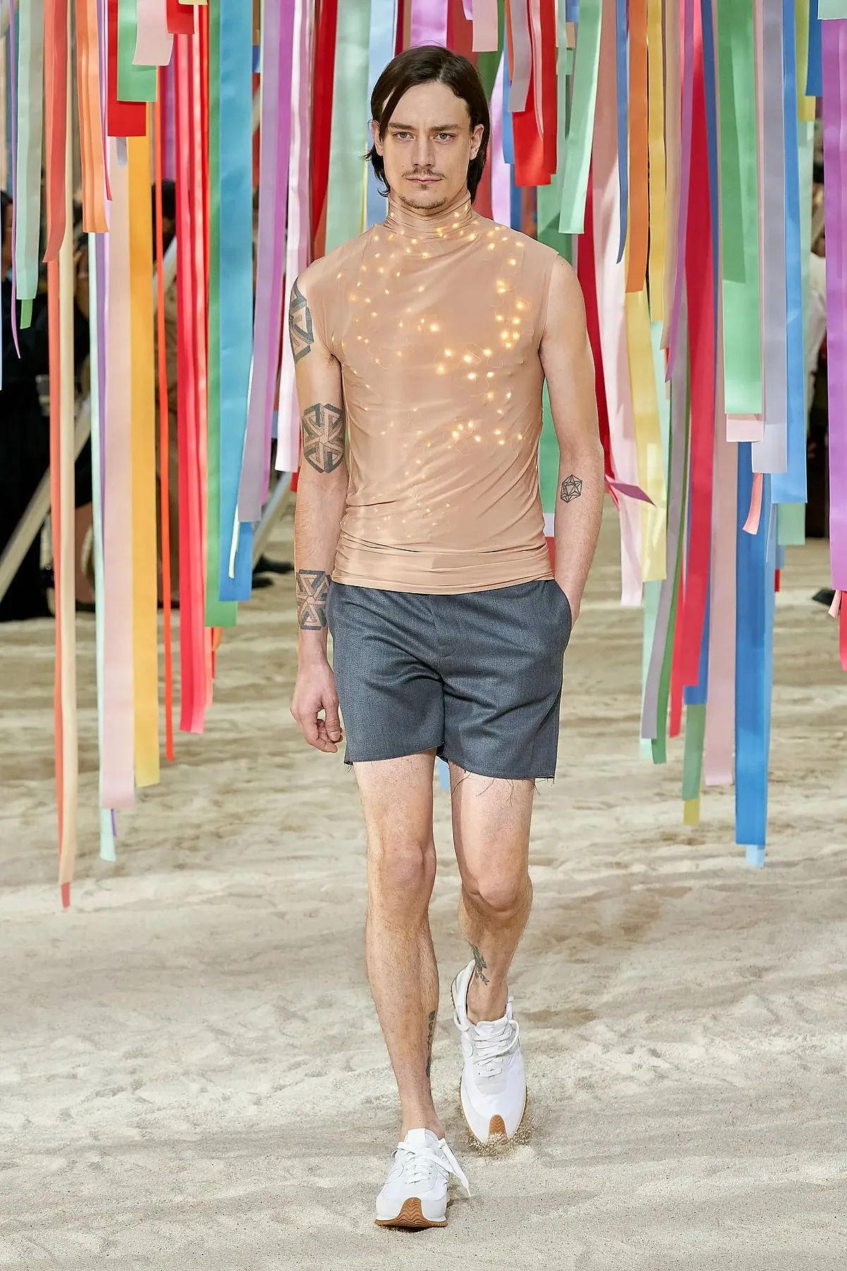 Jonathan Anderson opened Loewe’s fall 2022 menswear show with a model wearing a sleeveless T-shirt and shorts 