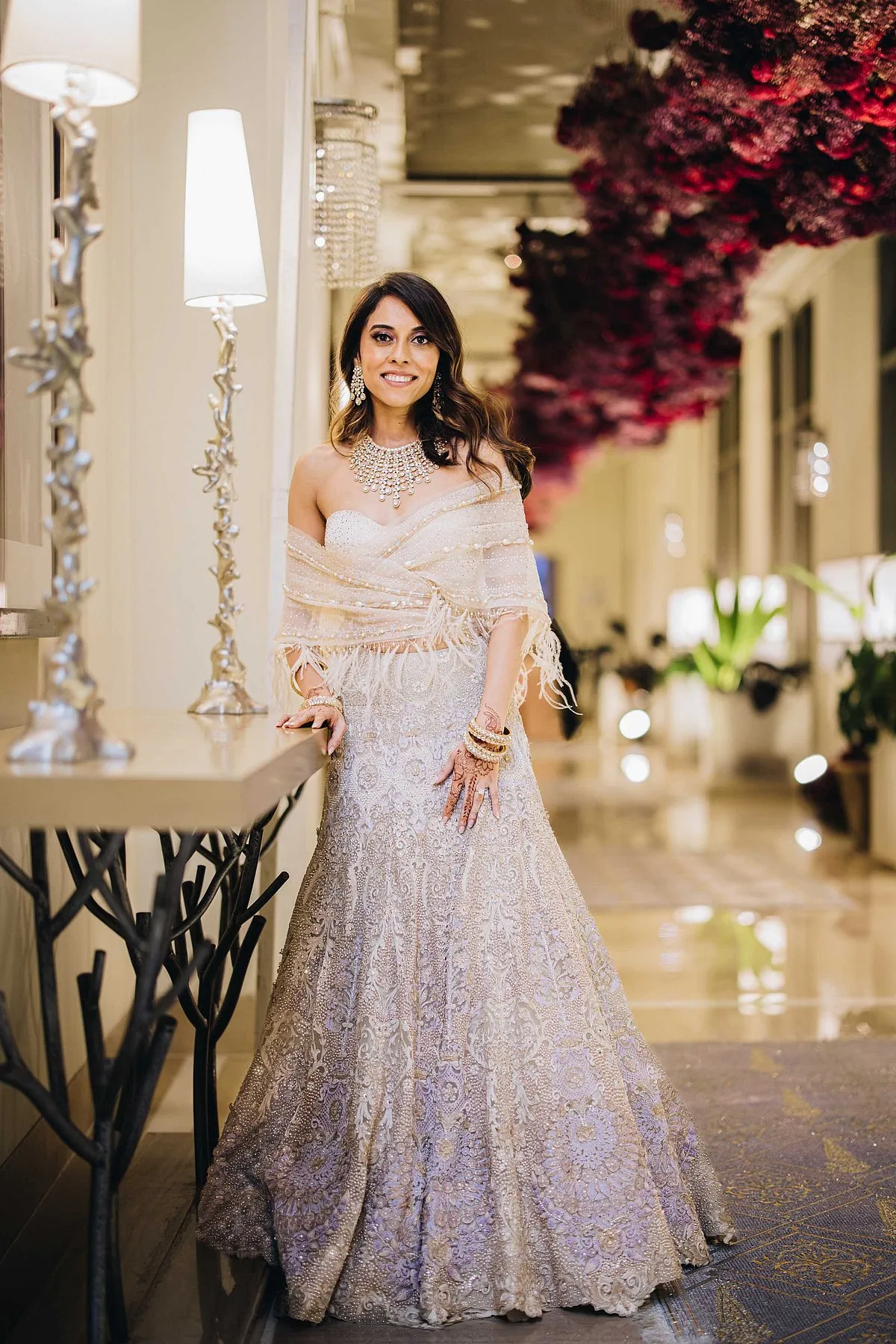 Chaitanya wore a Tarun Tahiliani lehenga for the reception in Bengaluru. It was silver-champagne hue with hints of lavender with a scarf–instead of a dupatta–that was wrapped around the corset with feathers 