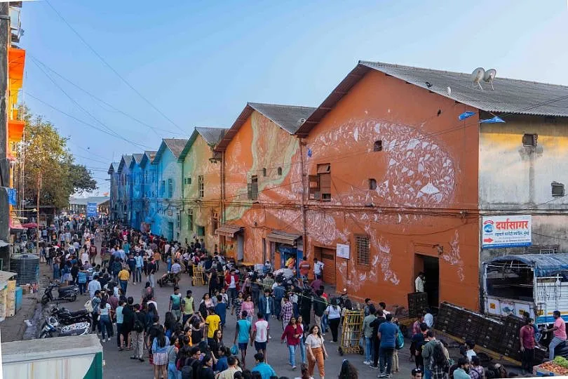 A mural depicting tribal Warli art by the Vayeda Brothers as a part of St+Art India's Mumbai Urban Art Festival 