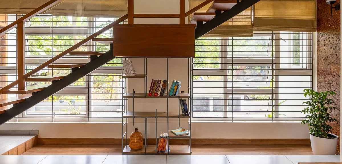 The staircase has a quaint bookshelf nestled under it 
