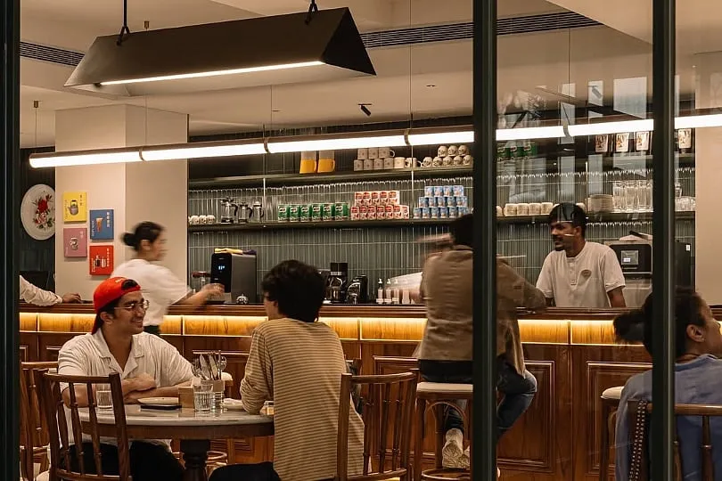 The geometric tiles and wooden stools are placed among decor sourced from local flea markets in Malaysia. Image: Instagram.com/kopitiamlah 